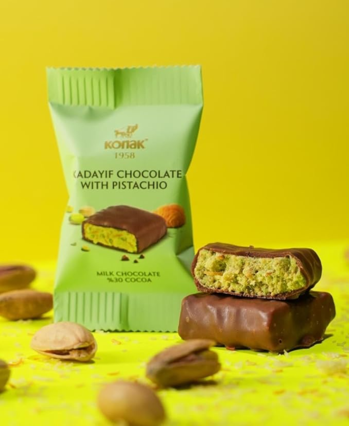 Green packaging of Nadayif Chocolate with Pistachio on a yellow background, bites deal