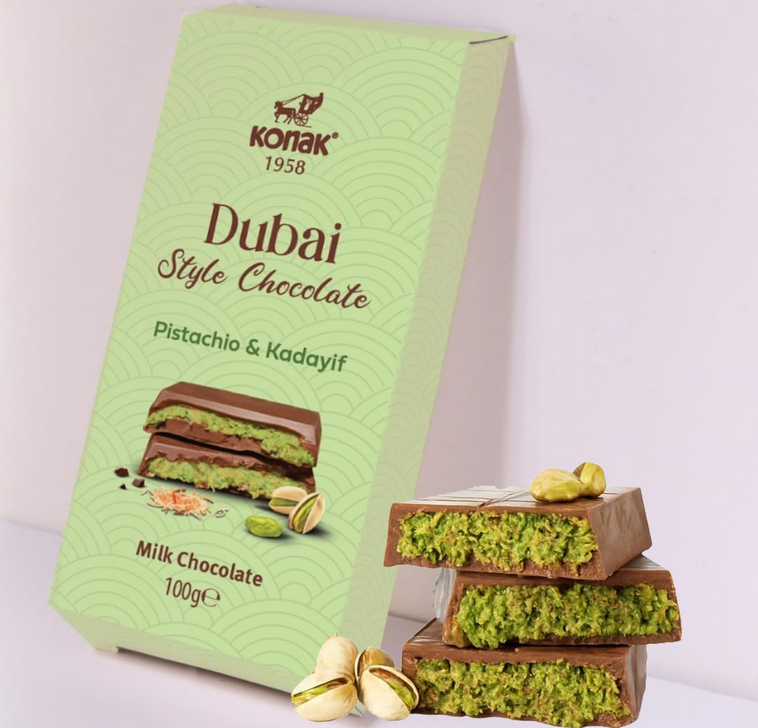 Konak Dubai Style Chocolate packaging with chocolate bars and pistachios on a light background